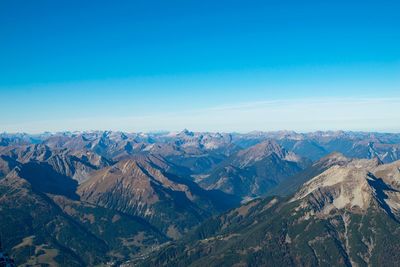 Scenic view of snowcapped mountains against blue sky