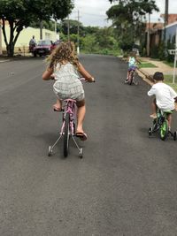Rear view of people riding bicycle