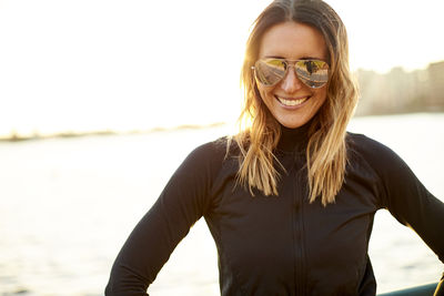 A backlit outdoor portrait of a happy athletic woman.