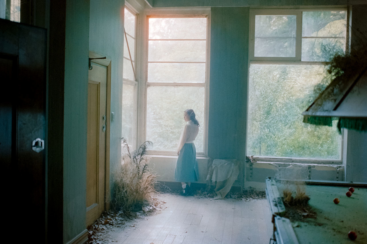 window, one person, day, side view, young adult, indoors, domestic room, sitting, real people, adult, full length, nature, entrance, women, door, sunlight, lifestyles, young women, contemplation, hairstyle