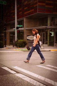 Full length of young woman walking on street