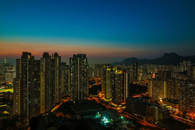 High angle view of illuminated buildings against sky at night