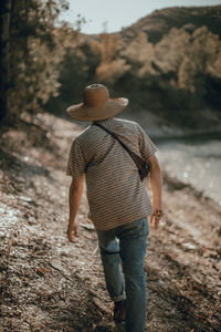 Rear view of man with umbrella walking on land