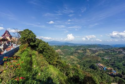 Scenic view of trees and houses against sky