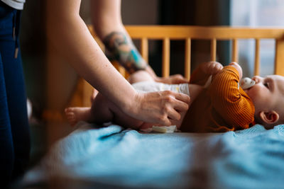 Mom changing baby diaper. 5 months toddler