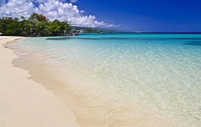 View of calm beach against blue sky