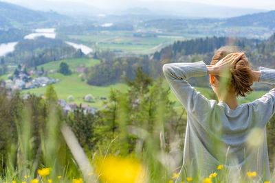 Rear view of woman sitting on mountain