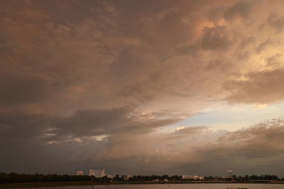 Scenic view of dramatic sky over city during sunset