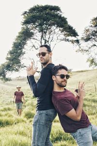 Friends on field against trees