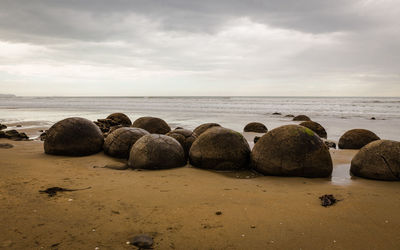 Rocks on beach against sky