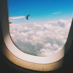 Cropped image of airplane flying over clouds