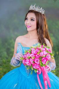 Smiling bride standing against plants