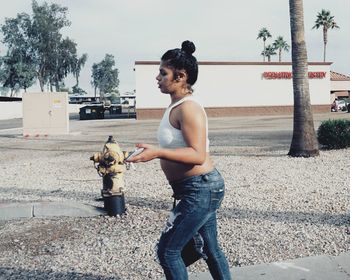 Side view of young man with dog standing outdoors