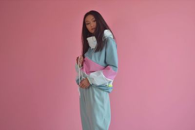 Full length of woman standing against pink background