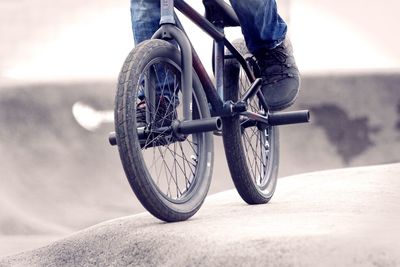 Low section of man riding bicycle on sports ramp at skateboard park