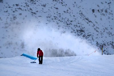 Woman skiing on snow covered field against sky