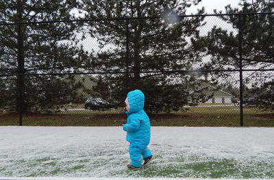 Rear view of boy standing in winter