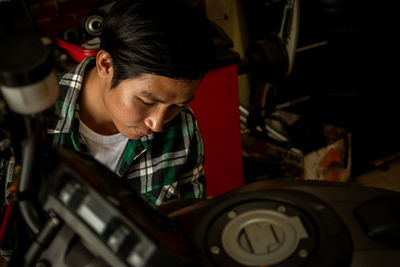 Mechanic repairing motorcycle at garage