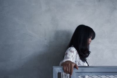 Woman standing against wall