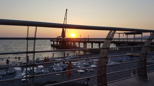 Bridge over sea against sky during sunset