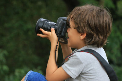 Side view of boy photographing