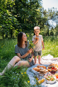 Family mom and son on picnic. smiling and enjoying summer on blanket in park.