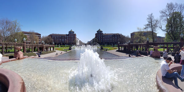 People at fountain against sky