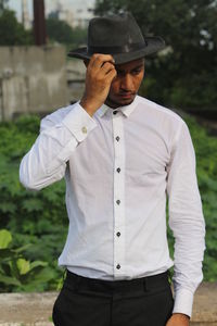 Young man wearing hat standing against blurred background