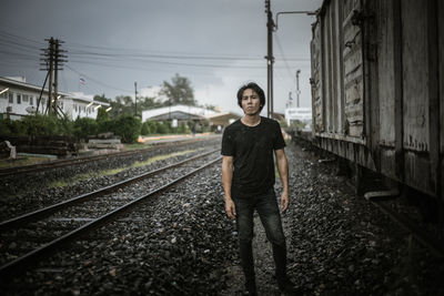 Portrait of man standing on railroad track