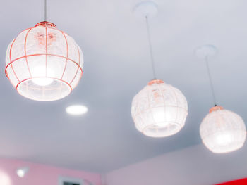 Low angle view of illuminated pendant light hanging from ceiling