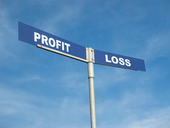 Low angle view of road sign against blue sky