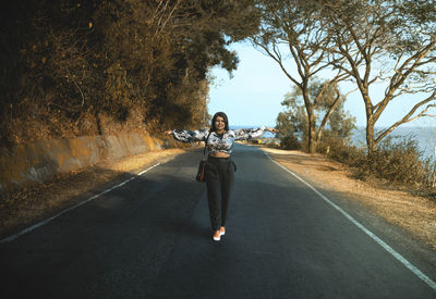 Full length portrait of woman on road