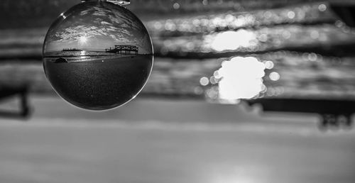 Close-up of crystal ball hanging against the sky