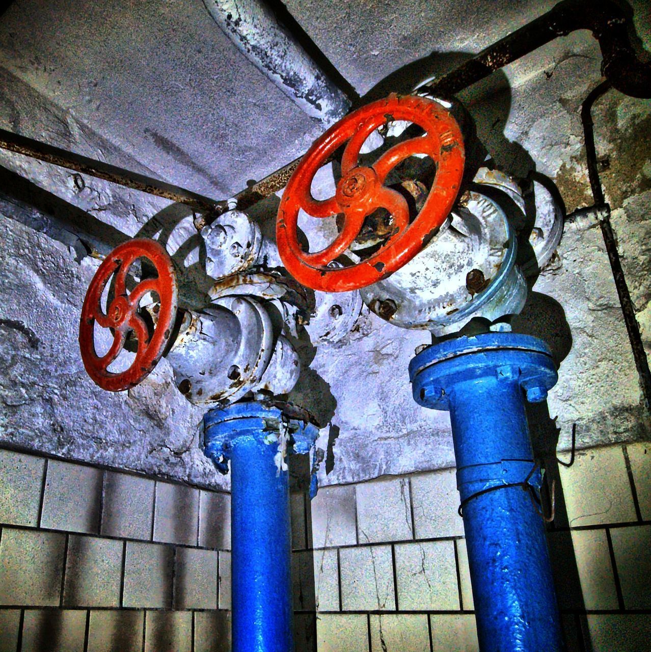 HIGH ANGLE VIEW OF PIPES ON METAL WALL