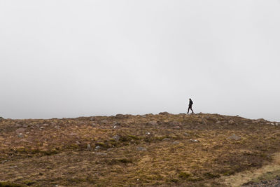 Man standing on field against clear sky