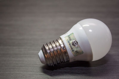 Close-up of light bulb on table