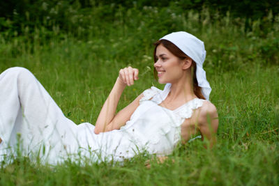 Portrait of young woman sitting on grass