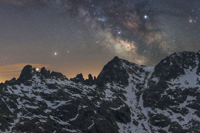 Scenic view of snowcapped mountains against sky at night