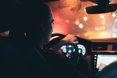 Rear view of woman watching map while driving car