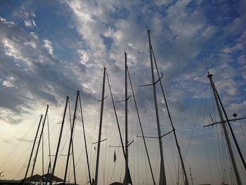 Low angle view of sailboats moored against sky