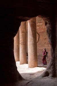 Side view of woman standing by rock formation