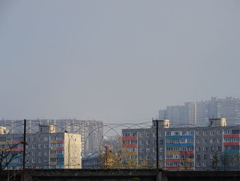 Buildings in city against clear sky