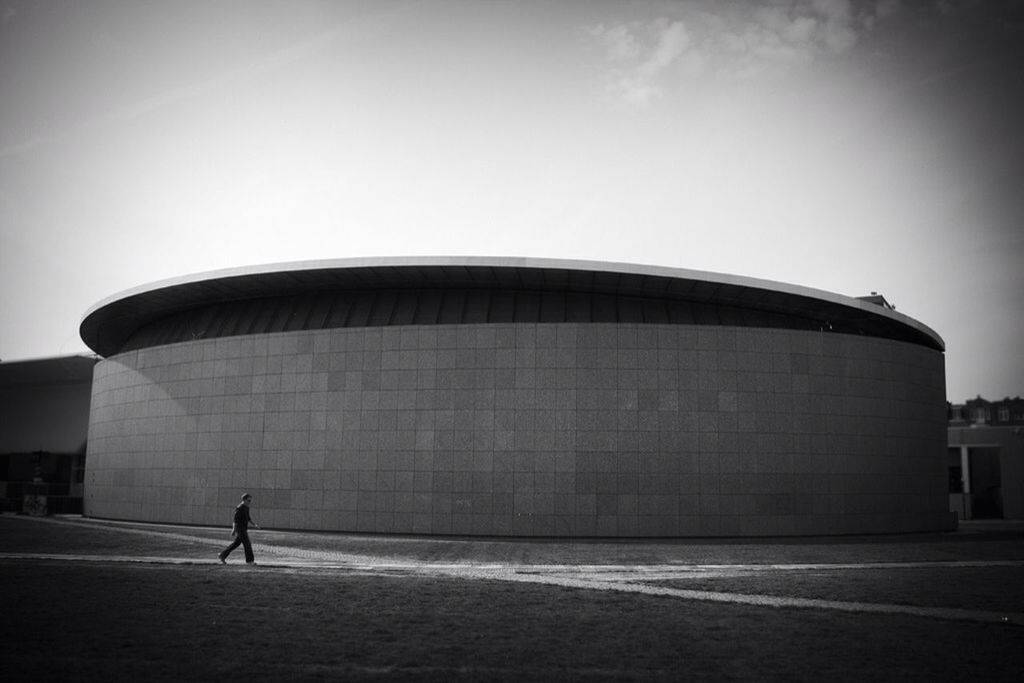 architecture, built structure, building exterior, full length, walking, men, lifestyles, street, wall - building feature, rear view, building, standing, sky, wall, city, day, side view, outdoors