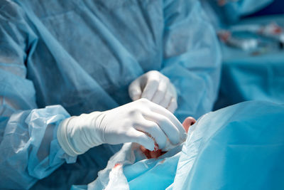 Midsection of surgeon performing surgery at hospital