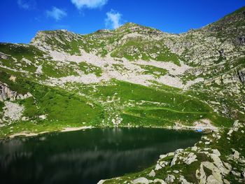 Scenic view of lake by mountains against sky