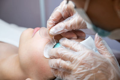 Close-up portrait of a woman on eyelash lamination procedure. 