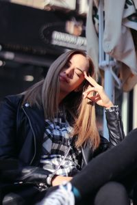 Young woman with eyes closed sitting outdoors