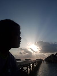 Silhouette man against sea during sunset