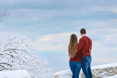 Rear view of people standing on snow covered landscape