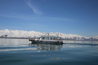 Ship floating on sea against blue sky